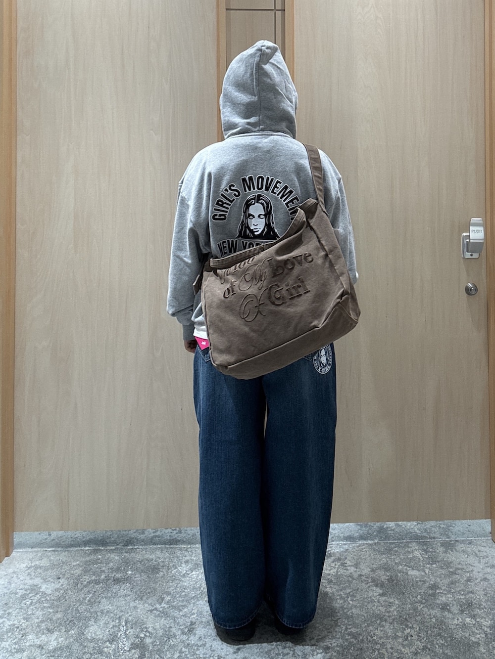 グレー系のパーカー、ホワイト系のTシャツ/カットソー、ブルー系のデニムパンツを着用したレディースの秋コーディネートの2枚目の写真