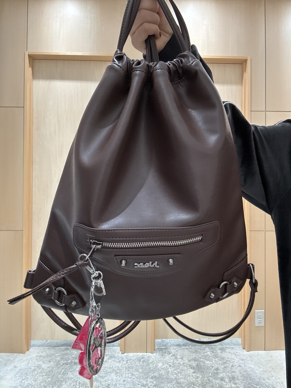 ブラック系のワンピース、ブラウン系のバックパック/リュック、ブルー系のデニムパンツを着用したレディースの秋コーディネートの5枚目の写真