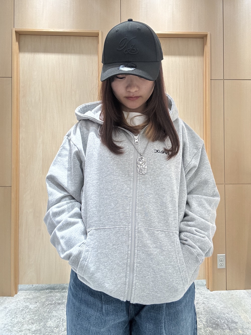 グレー系のパーカー、ホワイト系のTシャツ/カットソー、ブルー系のデニムパンツを着用したレディースの秋コーディネートの3枚目の写真