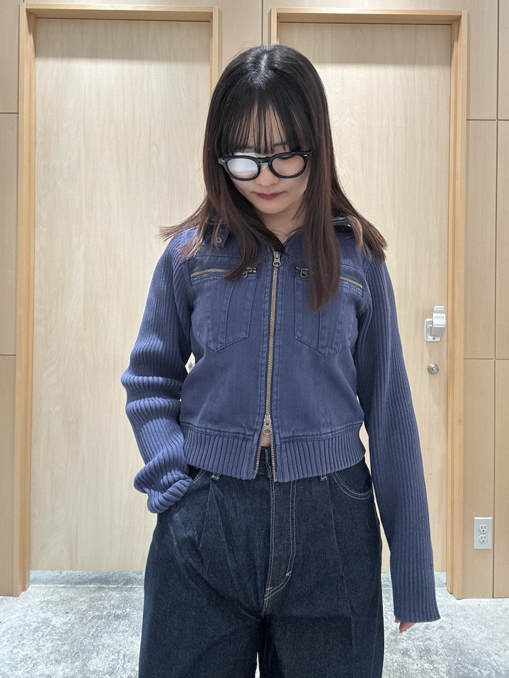 ブルー系のブルゾン、ブルー系のデニムパンツ、ホワイト系のハンドバッグを着用したレディースの夏コーディネートの3枚目の写真