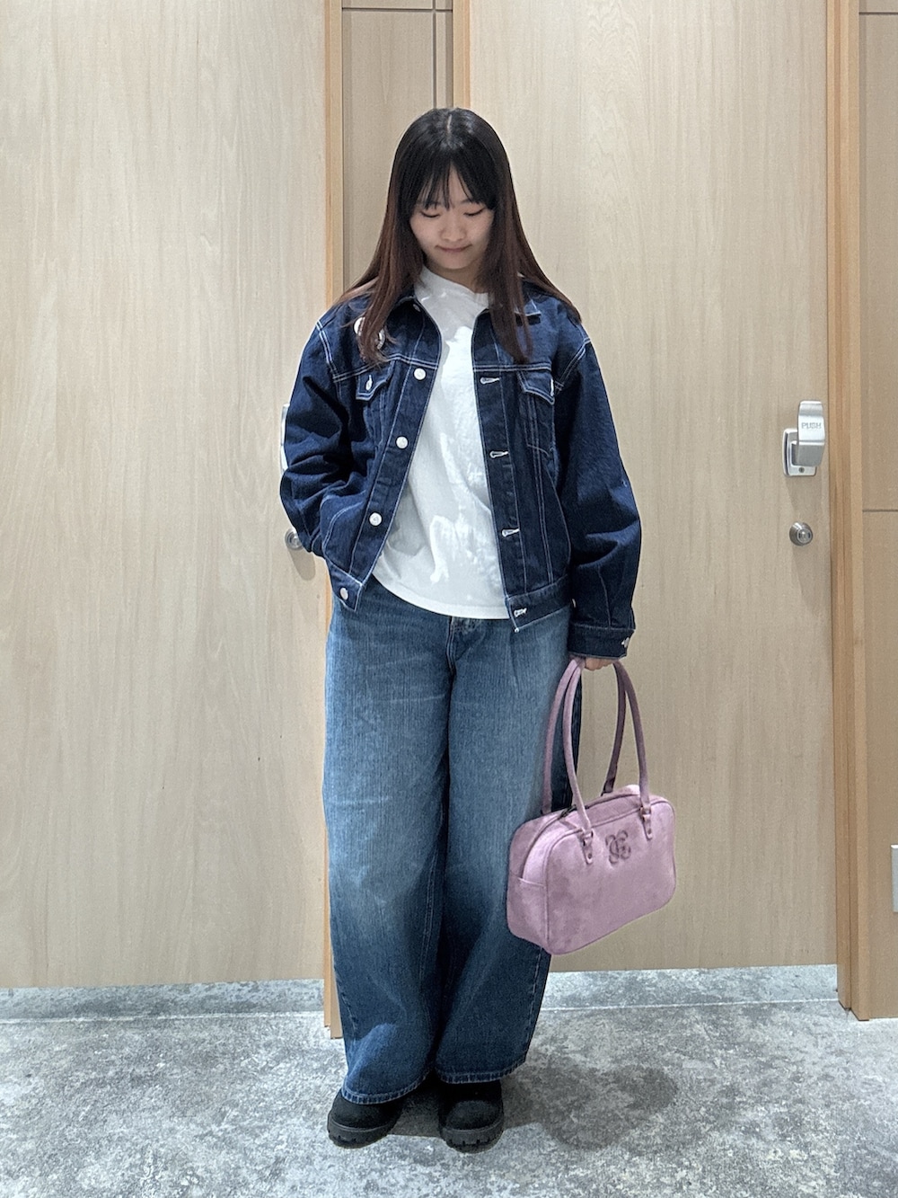 ブルー系のデニムパンツ、ブルー系のデニムジャケット、ホワイト系のTシャツ/カットソーを着用したレディースの秋コーディネートの2枚目の写真