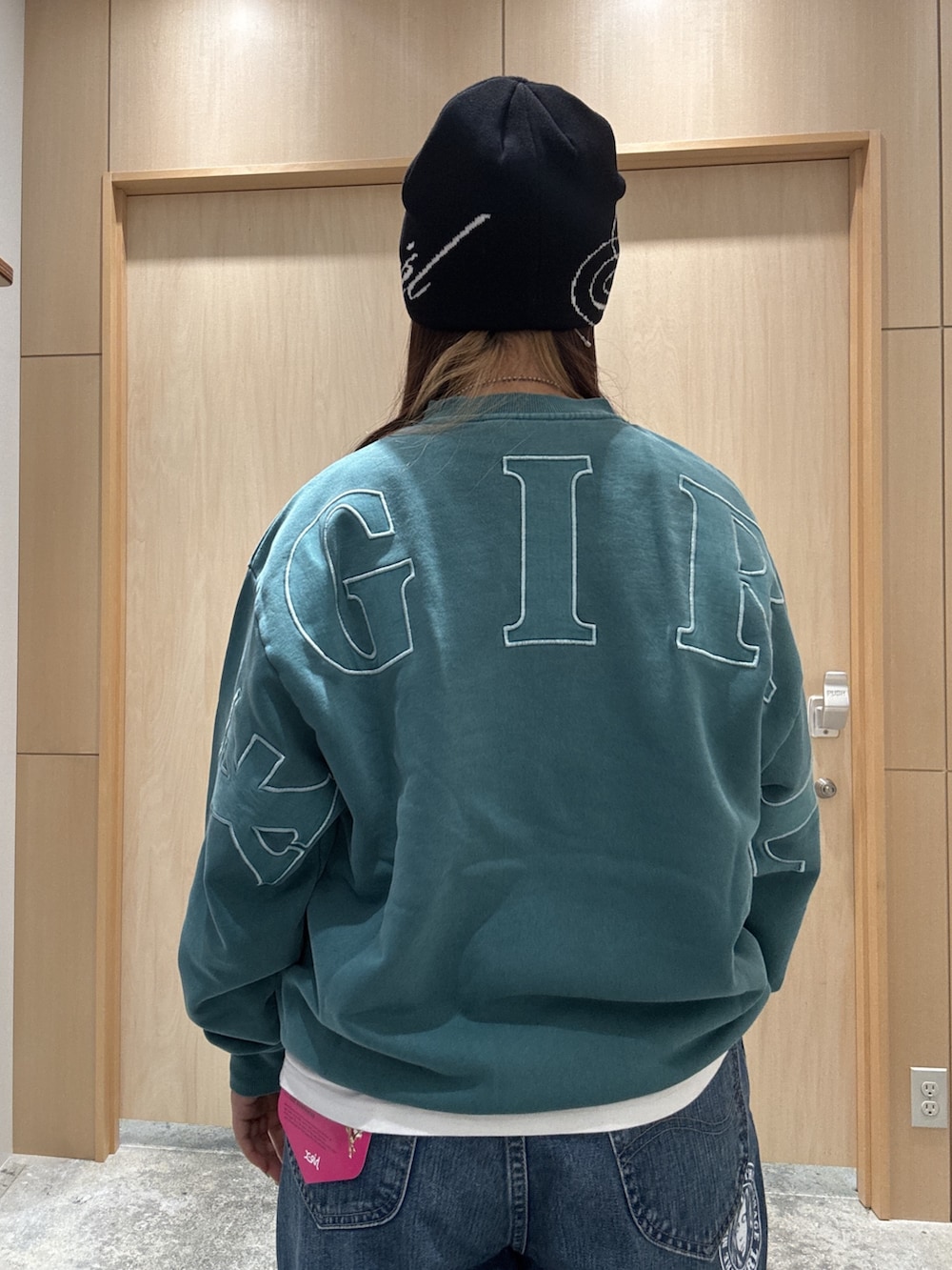 グリーン系のスウェット、ホワイト系のTシャツ/カットソー、ブルー系のデニムパンツを着用したレディースの秋コーディネートの4枚目の写真