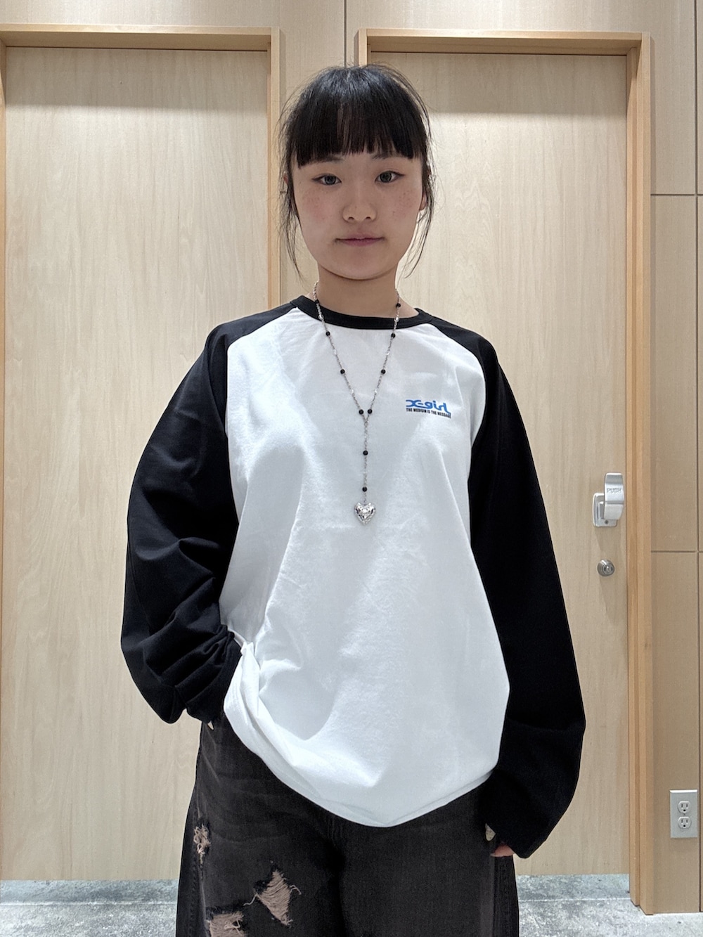 ホワイト系のTシャツ/カットソー、ブラック系のデニムパンツ、ブラウン系のショルダーバッグを着用したレディースの秋コーディネートの3枚目の写真
