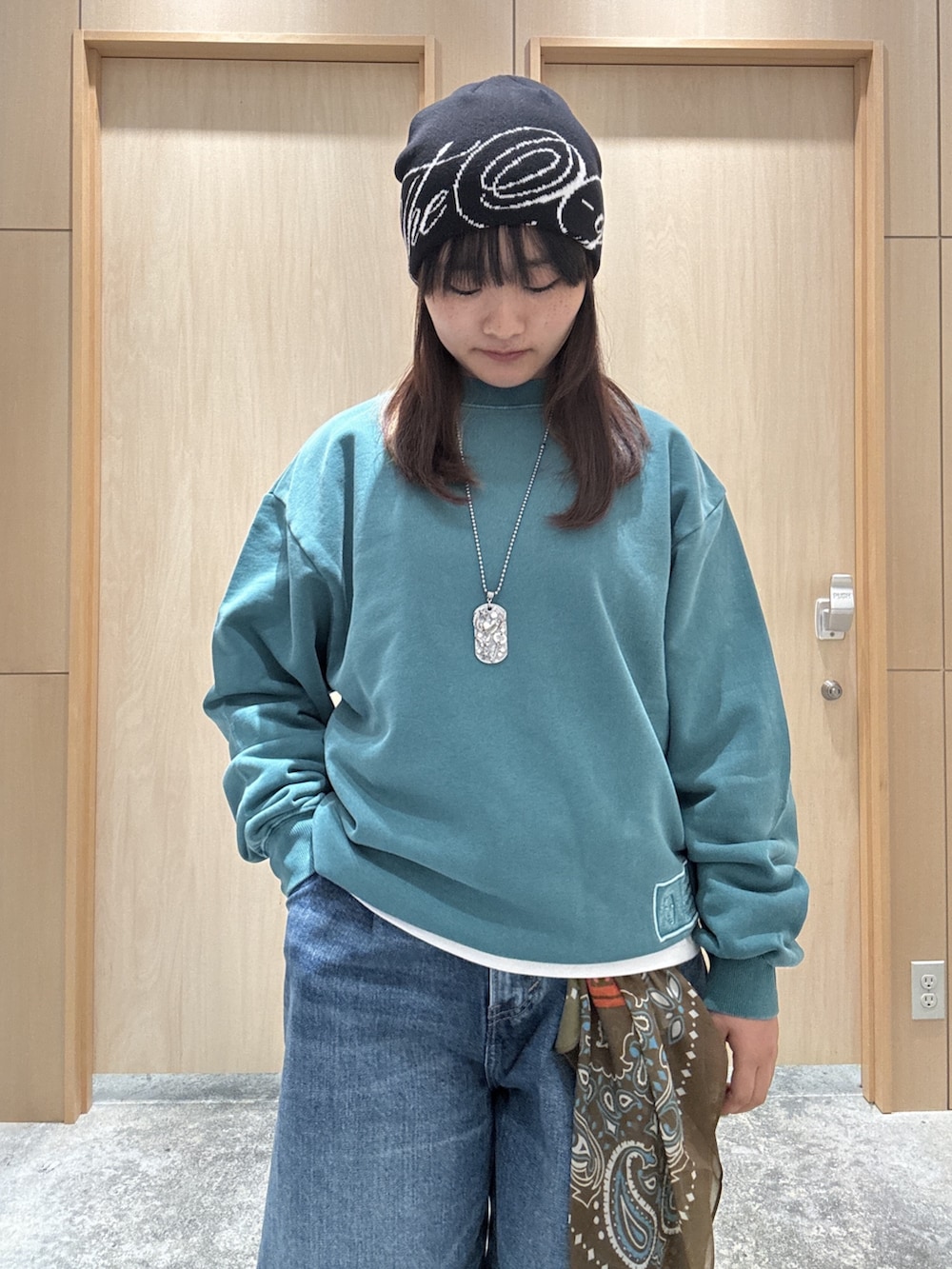 グリーン系のスウェット、ホワイト系のTシャツ/カットソー、ブルー系のデニムパンツを着用したレディースの秋コーディネートの3枚目の写真