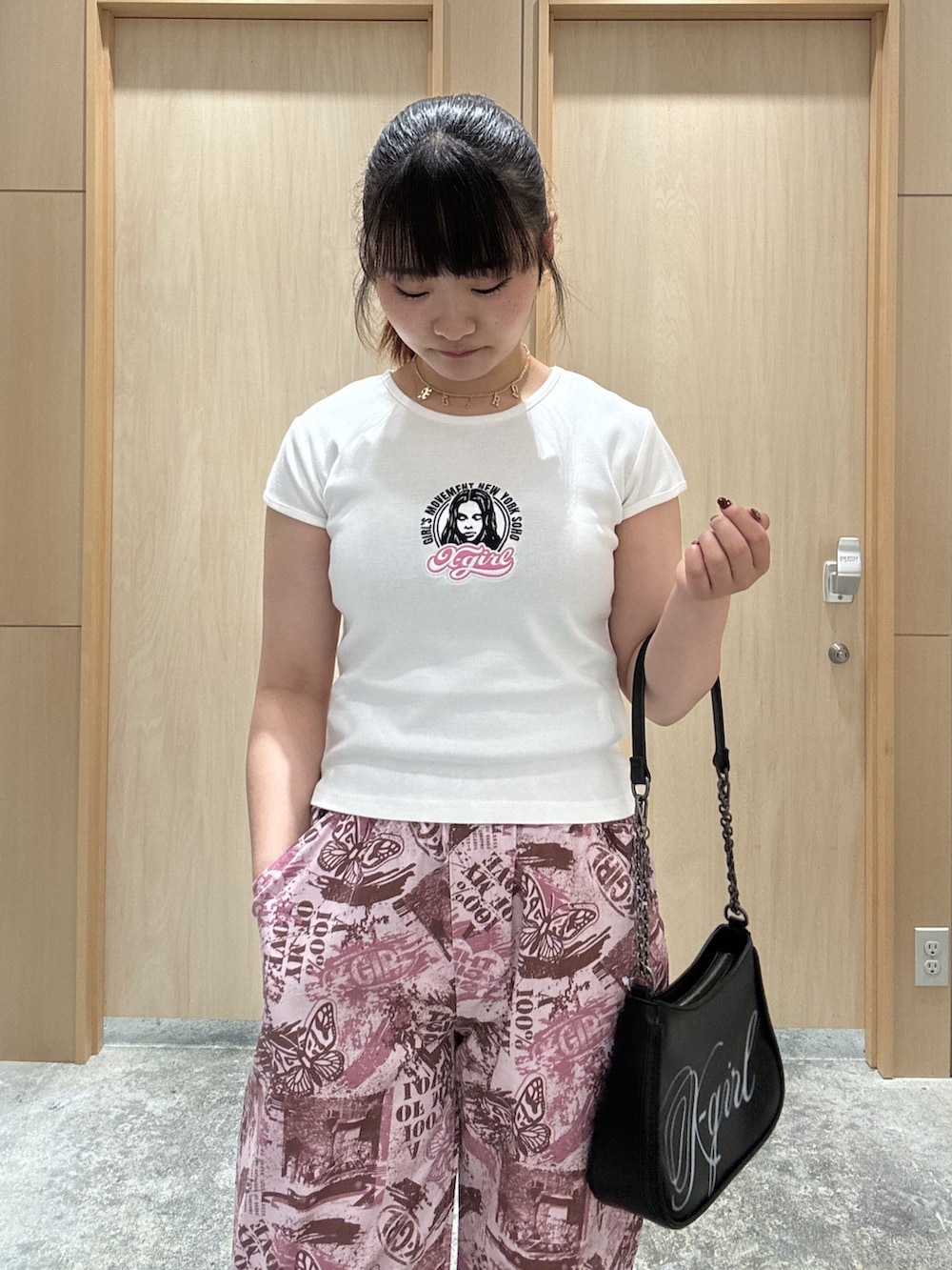 ピンク系のその他パンツ、ブラック系のショルダーバッグ、ホワイト系のTシャツ/カットソーを着用したレディースの夏コーディネートの3枚目の写真