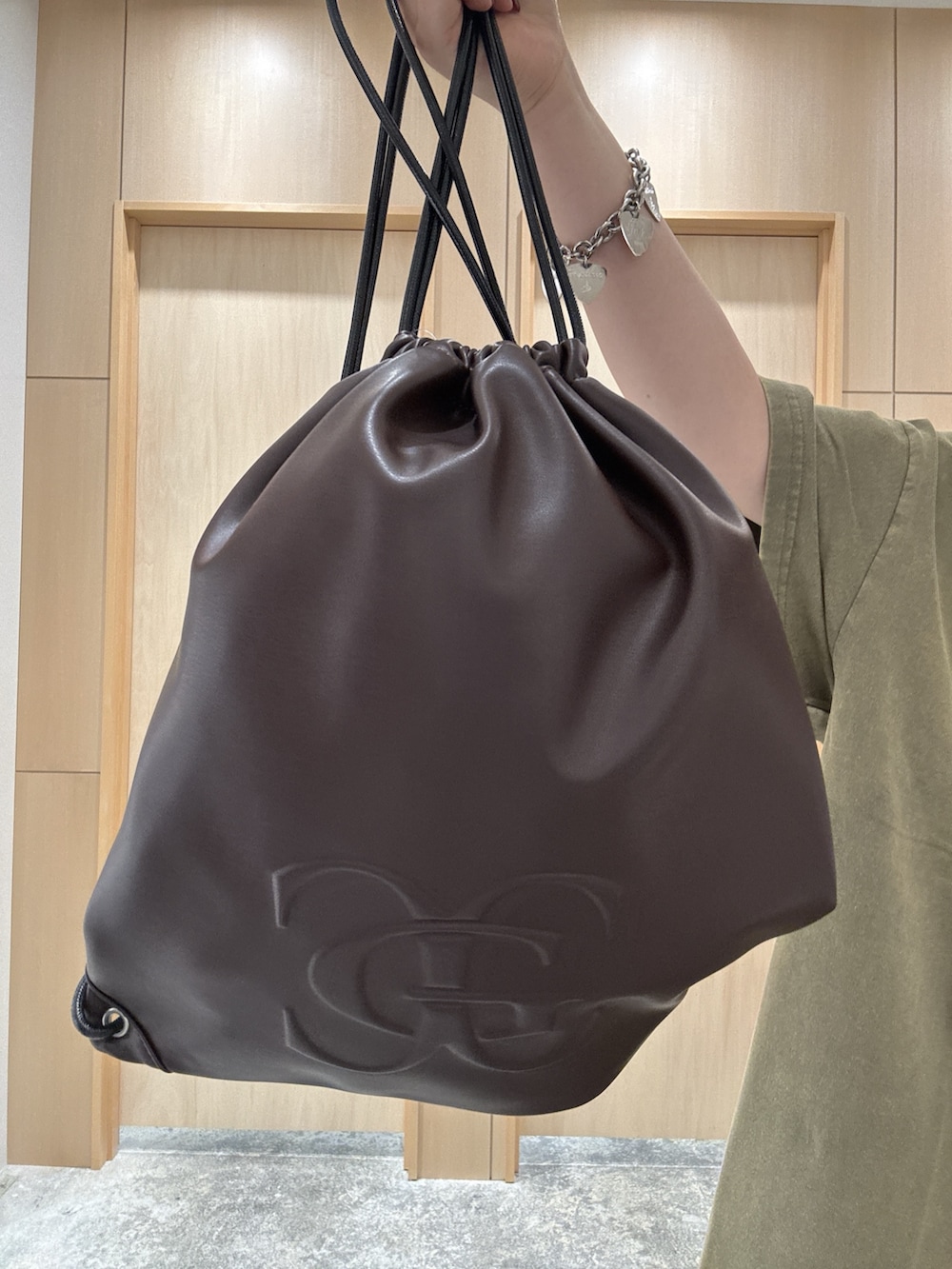 グリーン系のワンピース、ブラック系のデニムパンツ、ブラウン系のバックパック/リュックを着用したレディースの夏コーディネートの5枚目の写真