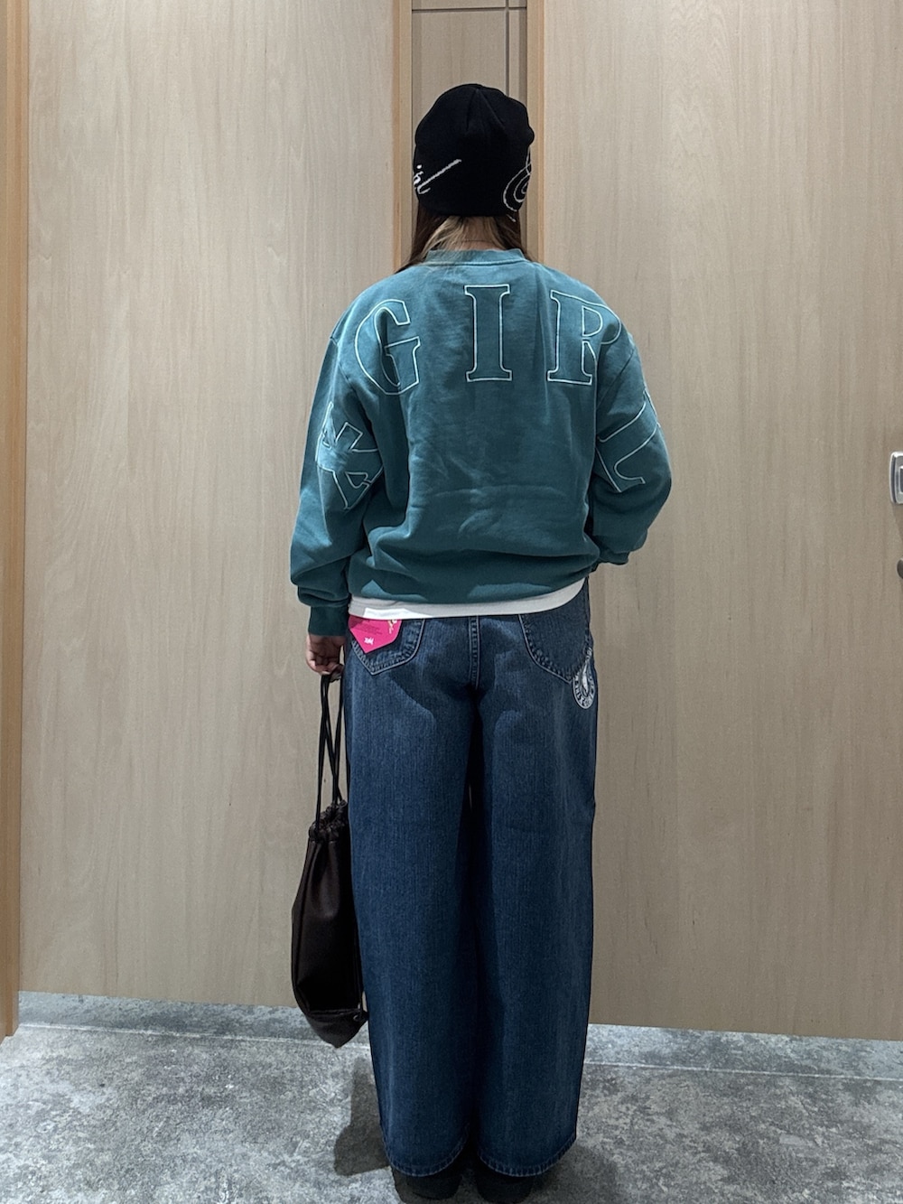 グリーン系のスウェット、ホワイト系のTシャツ/カットソー、ブルー系のデニムパンツを着用したレディースの秋コーディネートの2枚目の写真