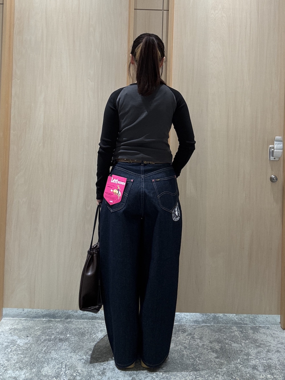 ブラウン系のバックパック/リュック、ブラック系のTシャツ/カットソー、ブラウン系のベルトを着用したレディースの夏コーディネートの2枚目の写真