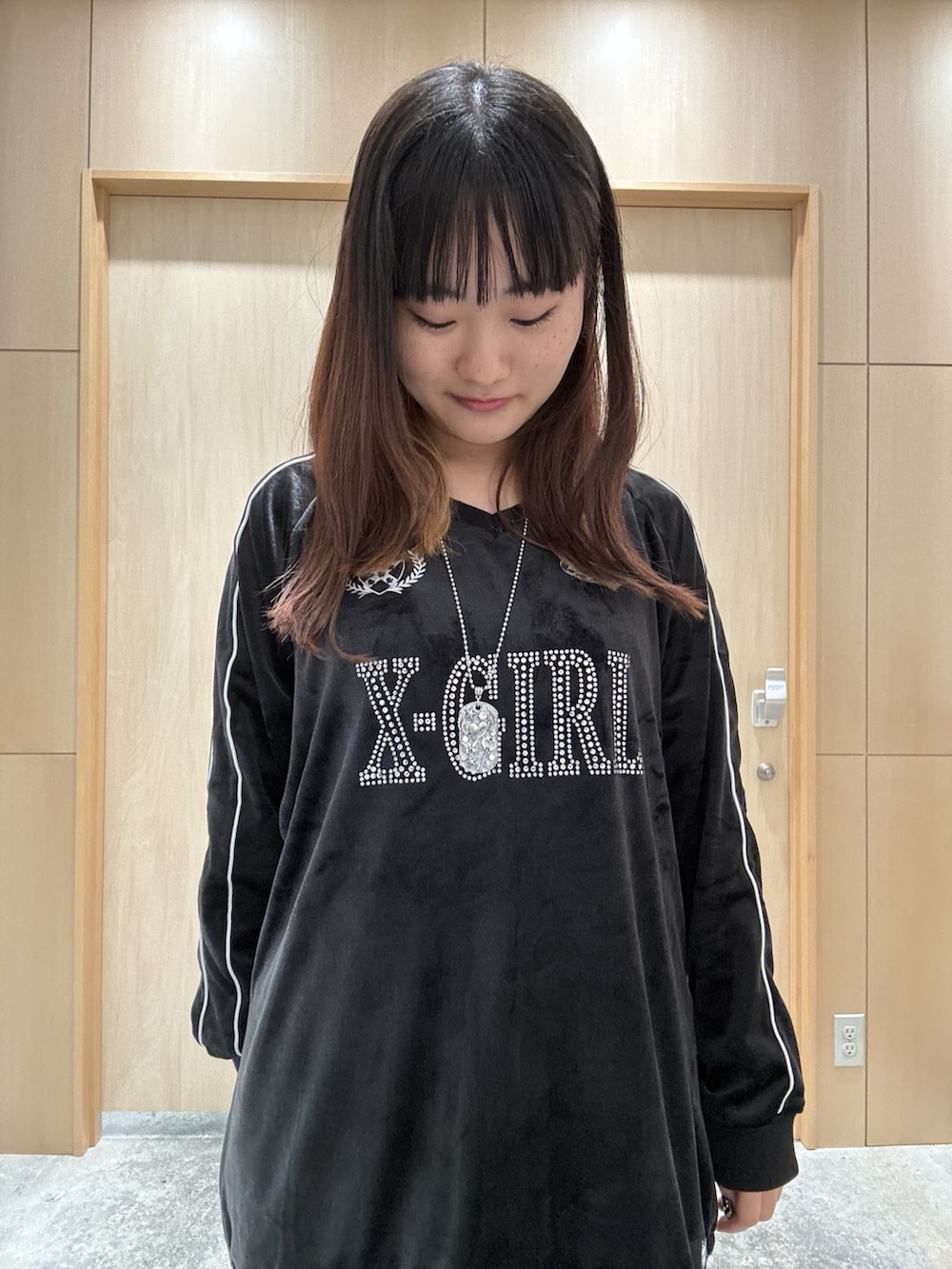 ブラック系のワンピース、ブラウン系のバックパック/リュック、ブルー系のデニムパンツを着用したレディースの秋コーディネートの3枚目の写真