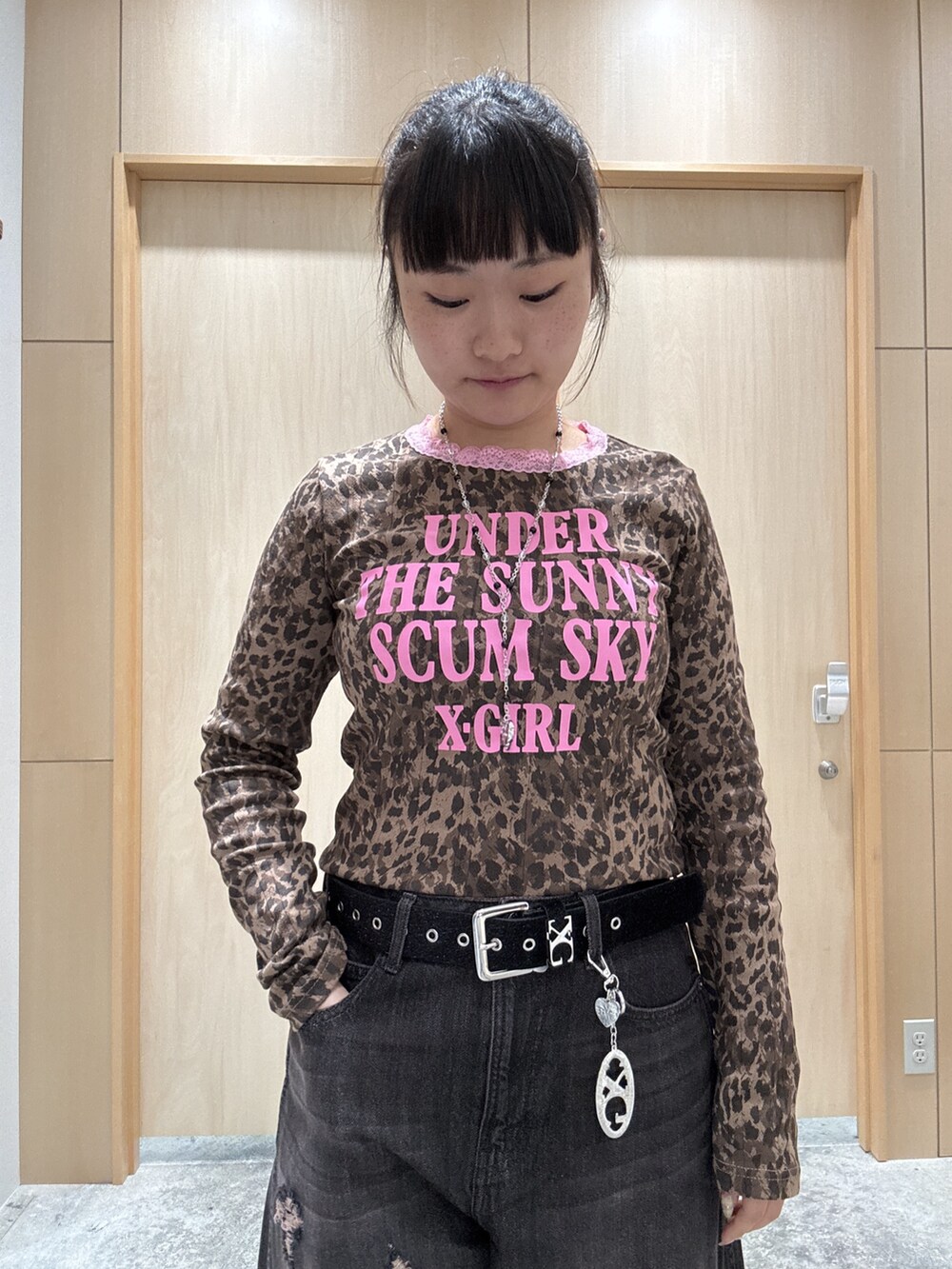 ブラック系のデニムパンツ、レッド系のハンドバッグ、ベージュ系のTシャツ/カットソーを着用したレディースの秋コーディネートの3枚目の写真