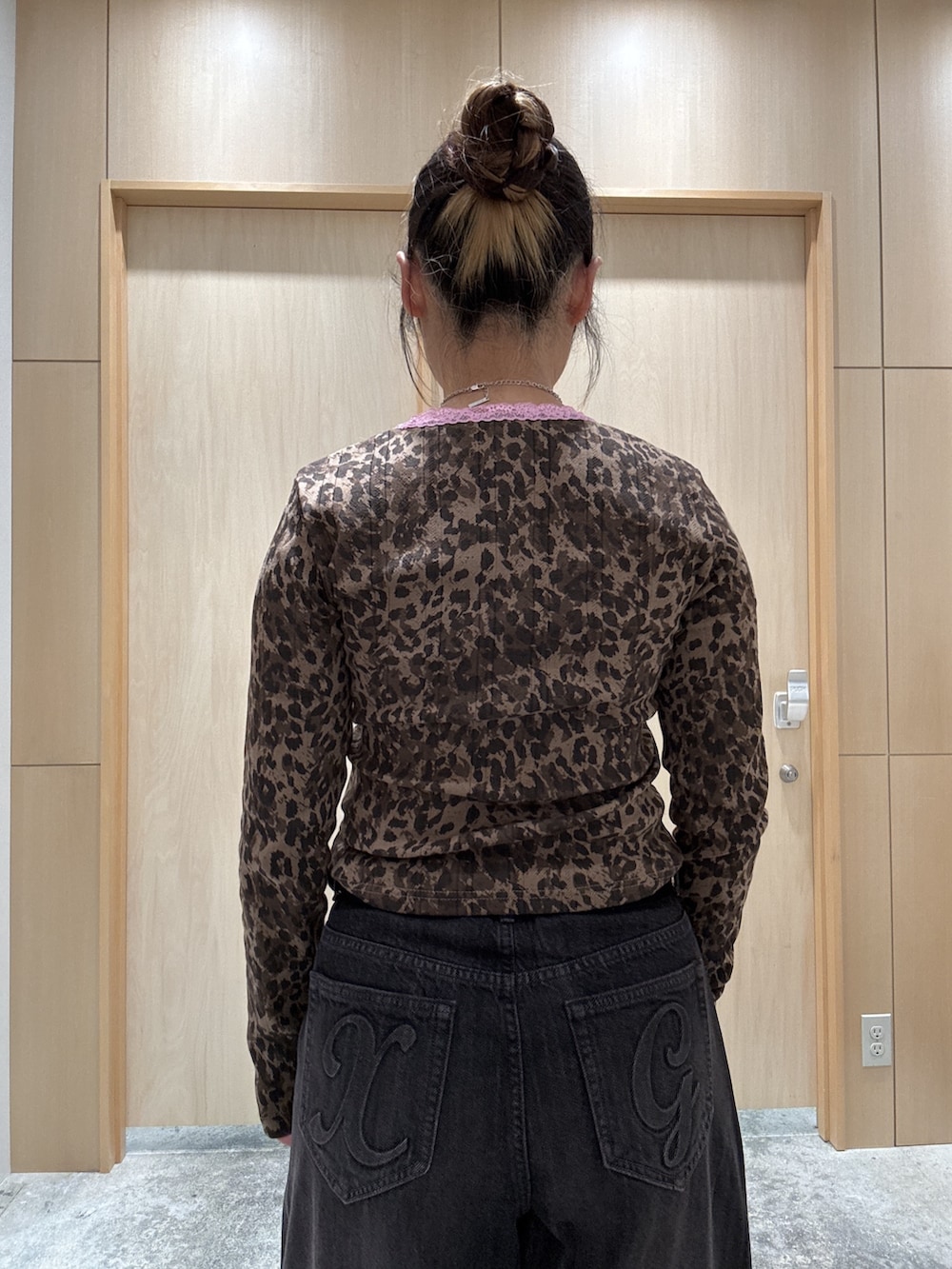ブラック系のデニムパンツ、レッド系のハンドバッグ、ベージュ系のTシャツ/カットソーを着用したレディースの秋コーディネートの4枚目の写真