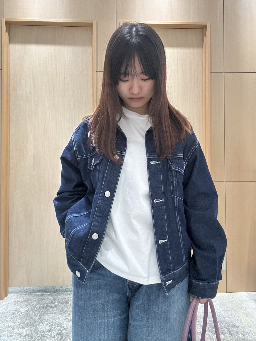 ブルー系のデニムパンツ、ブルー系のデニムジャケット、ホワイト系のTシャツ/カットソーを着用したレディースの秋コーディネートの3枚目の写真