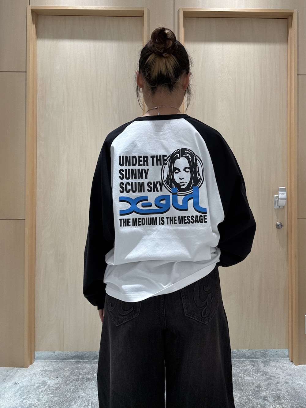 ホワイト系のTシャツ/カットソー、ブラック系のデニムパンツ、ブラウン系のショルダーバッグを着用したレディースの秋コーディネートの4枚目の写真