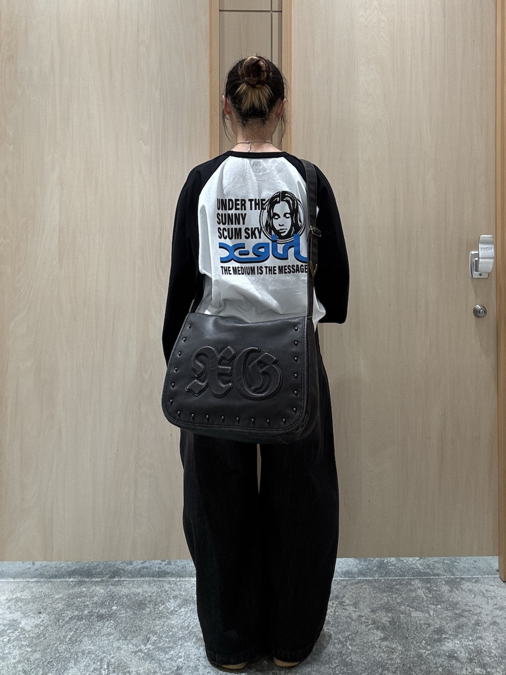 ホワイト系のTシャツ/カットソー、ブラック系のデニムパンツ、ブラウン系のショルダーバッグを着用したレディースの秋コーディネートの2枚目の写真