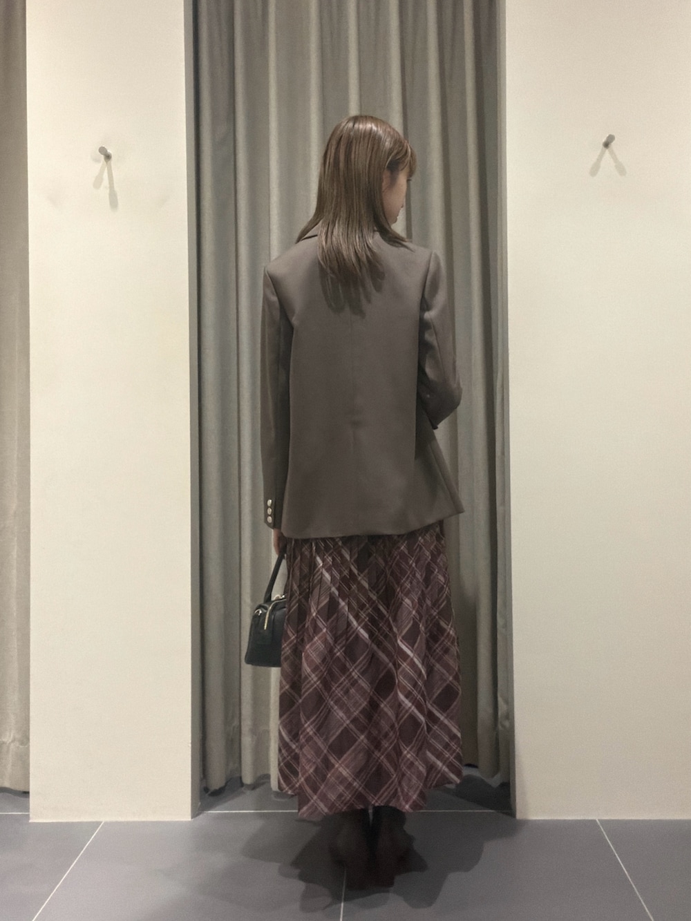 ブラウン系のワンピース、ブラック系のボストンバッグ、ブラウン系のブーツを着用したレディースの夏コーディネートの3枚目の写真