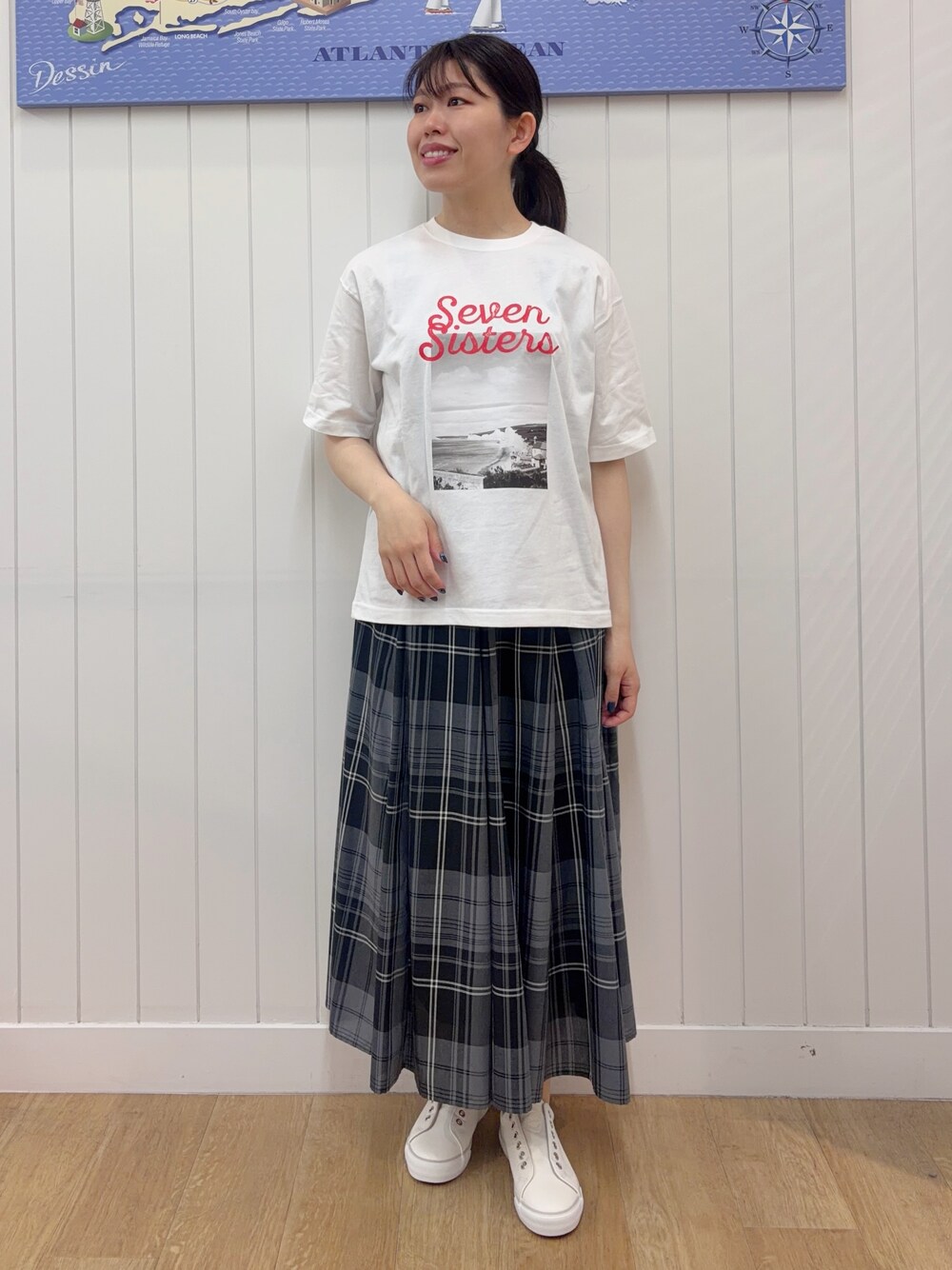 ホワイト系のTシャツ/カットソー、グリーン系のスカート、ホワイト系のスニーカーを着用したレディースの春コーディネートの2枚目の写真