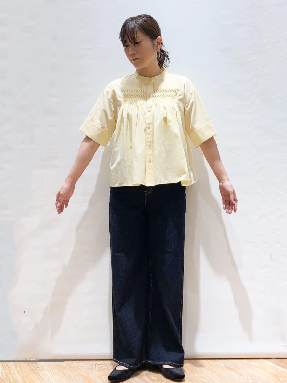 イエロー系のシャツ/ブラウス、ブルー系のデニムパンツ、ブラック系のトートバッグを着用したレディースの夏コーディネートの2枚目の写真