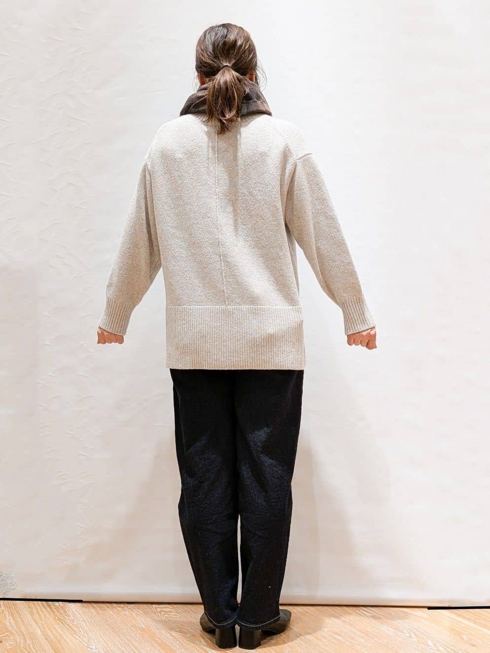 グレー系のニット/セーター、ブルー系のデニムパンツ、ブラウン系のトートバッグを着用したレディースの冬コーディネートの3枚目の写真