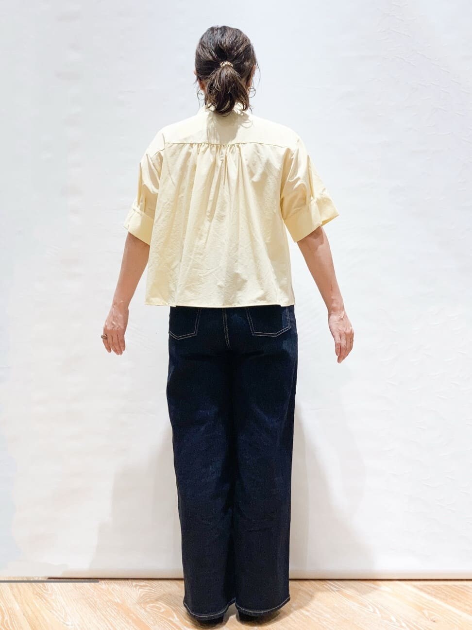 イエロー系のシャツ/ブラウス、ブルー系のデニムパンツ、ブラック系のトートバッグを着用したレディースの夏コーディネートの3枚目の写真
