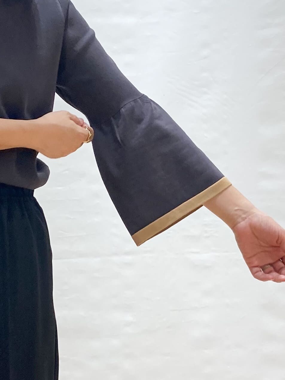 グレー系のニット/セーター、ブラック系のその他パンツ、ベージュ系のトートバッグを着用したレディースの秋コーディネートの5枚目の写真