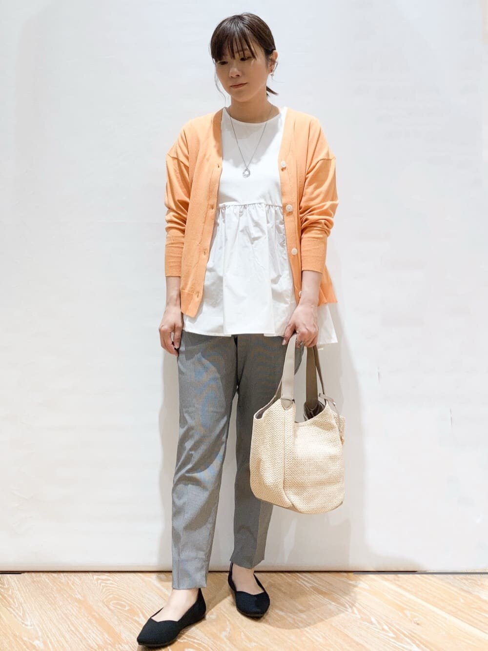 オレンジ系のカーディガン/ボレロ、ホワイト系のTシャツ/カットソー、ブラック系のその他パンツを着用したレディースの春コーディネートの2枚目の写真