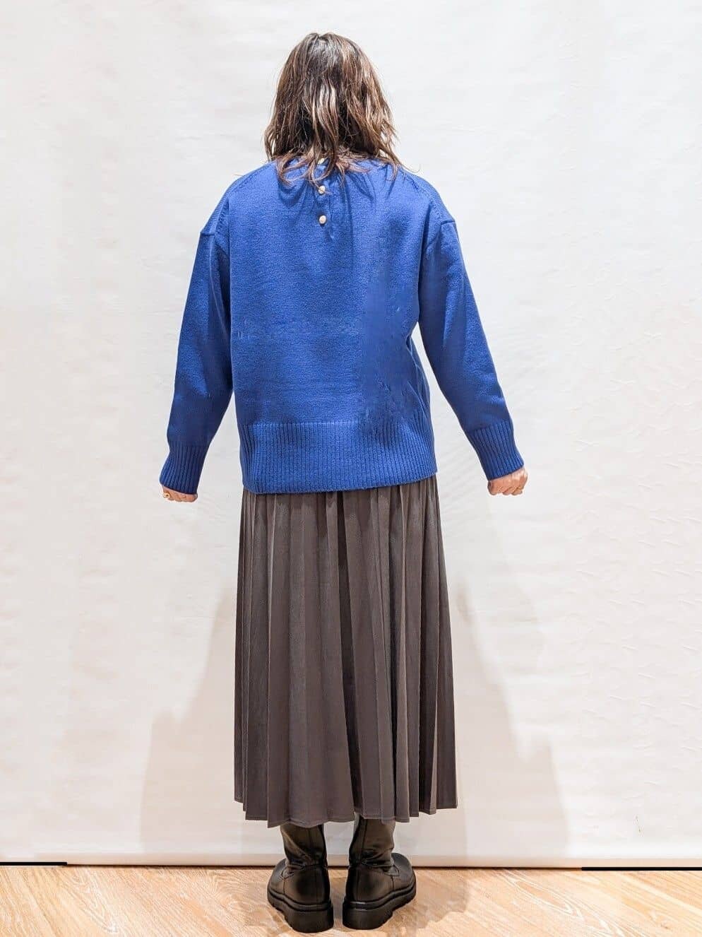 ホワイト系のTシャツ/カットソー、ブルー系のニット/セーター、グレー系のスカートを着用したレディースの秋コーディネートの5枚目の写真