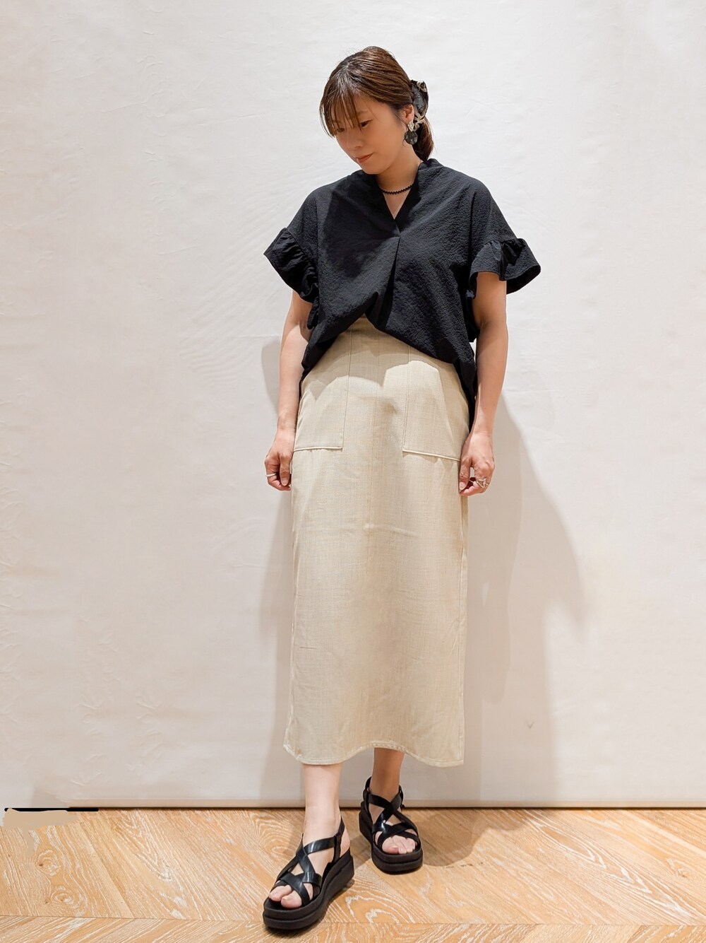 ブラック系のシャツ/ブラウス、ベージュ系のスカート、ホワイト系のトートバッグを着用したレディースの春コーディネートの5枚目の写真