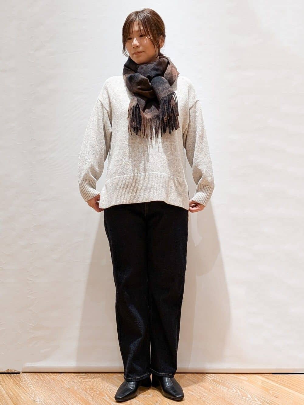 グレー系のニット/セーター、ブルー系のデニムパンツ、ブラウン系のトートバッグを着用したレディースの冬コーディネートの2枚目の写真