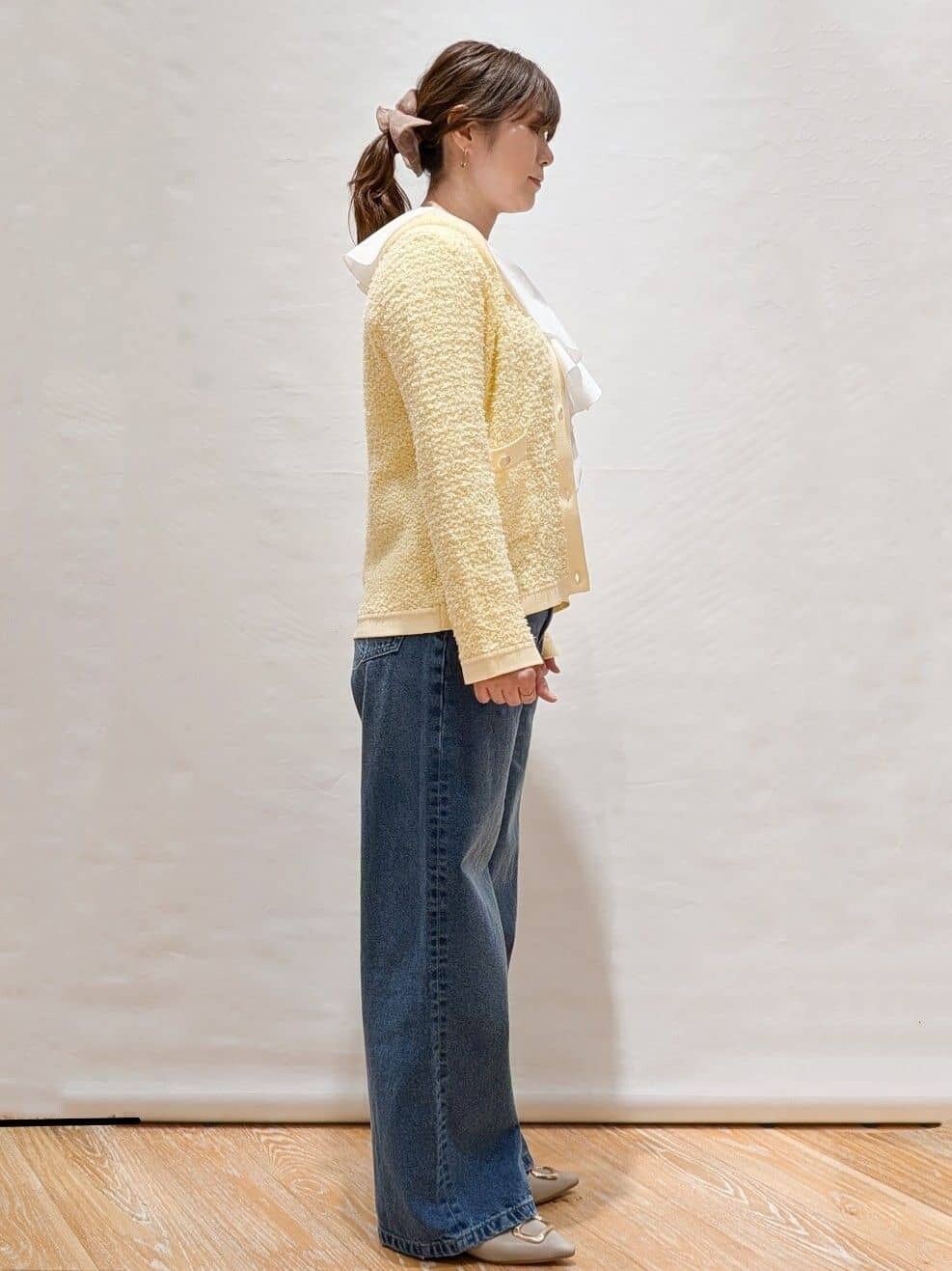 イエロー系のカーディガン/ボレロ、ホワイト系のシャツ/ブラウス、ブルー系のデニムパンツを着用したレディースの冬コーディネートの4枚目の写真