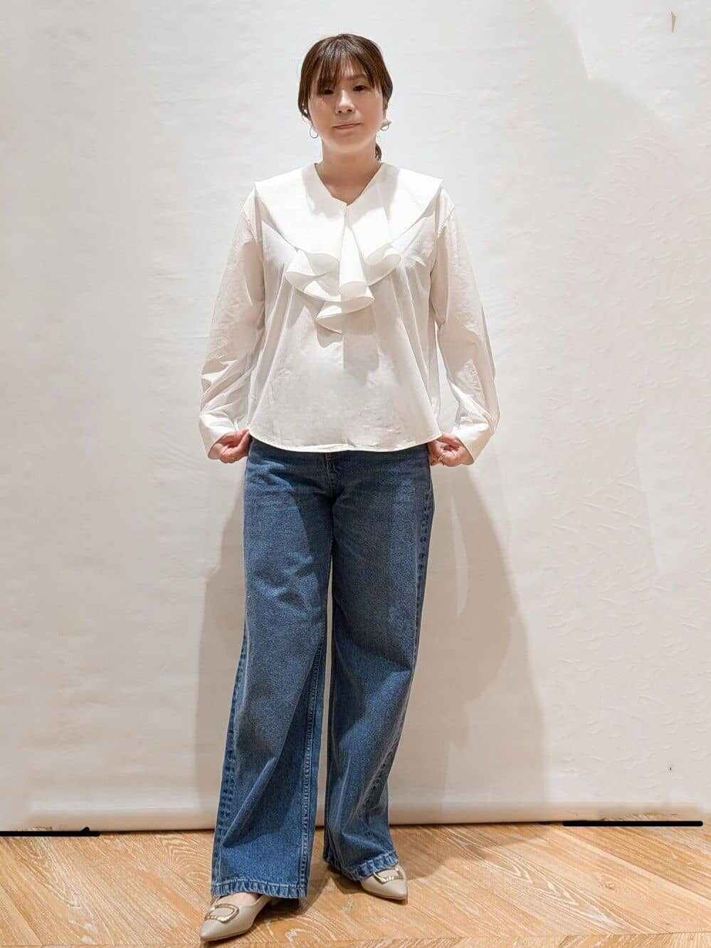 イエロー系のカーディガン/ボレロ、ホワイト系のシャツ/ブラウス、ブルー系のデニムパンツを着用したレディースの冬コーディネートの5枚目の写真