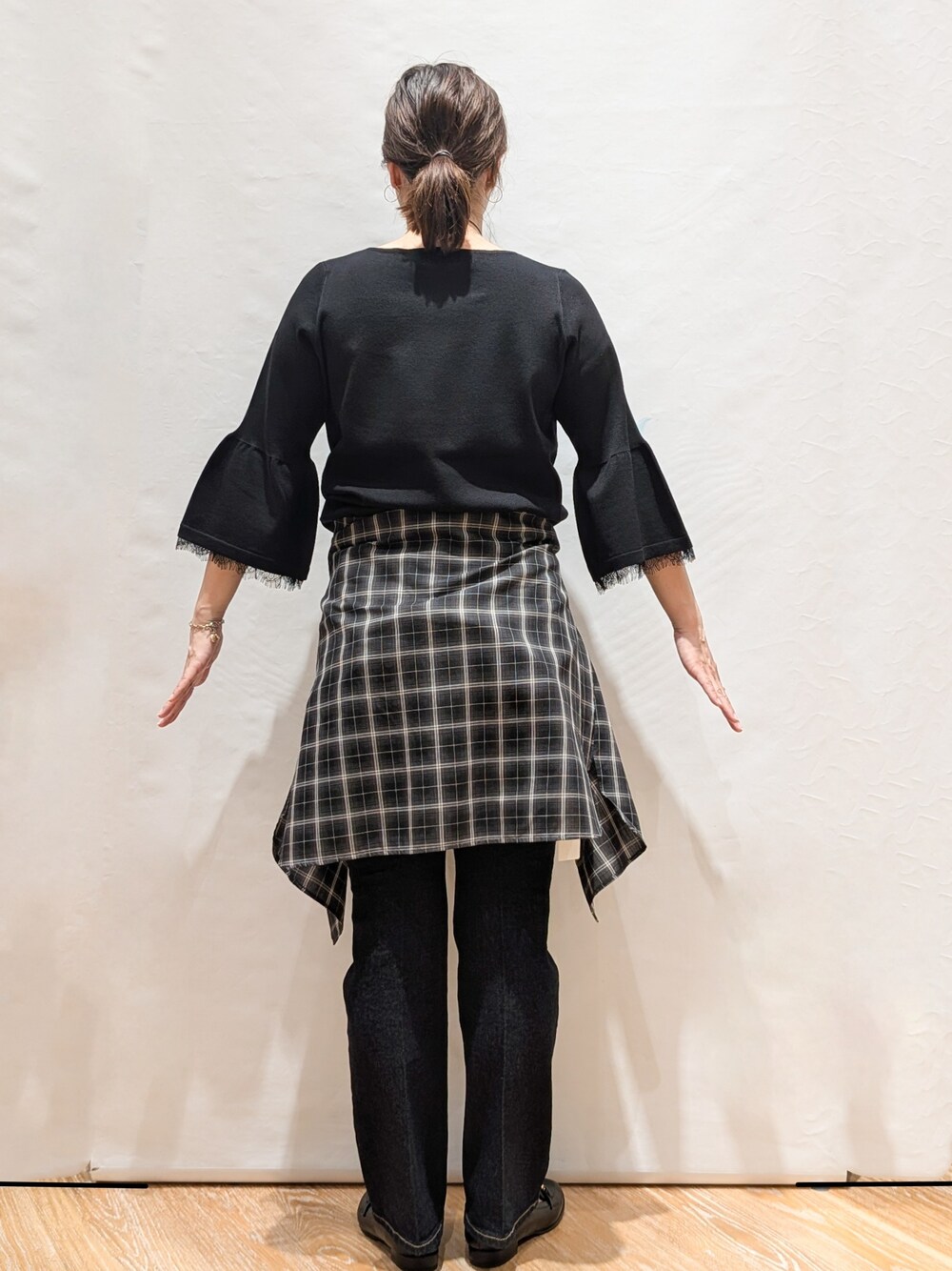 グレー系のシャツ/ブラウス、ブラック系のニット/セーター、ブルー系のデニムパンツを着用したレディースの秋コーディネートの4枚目の写真
