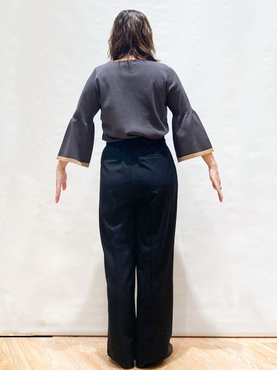 グレー系のニット/セーター、ブラック系のその他パンツ、ベージュ系のトートバッグを着用したレディースの秋コーディネートの3枚目の写真