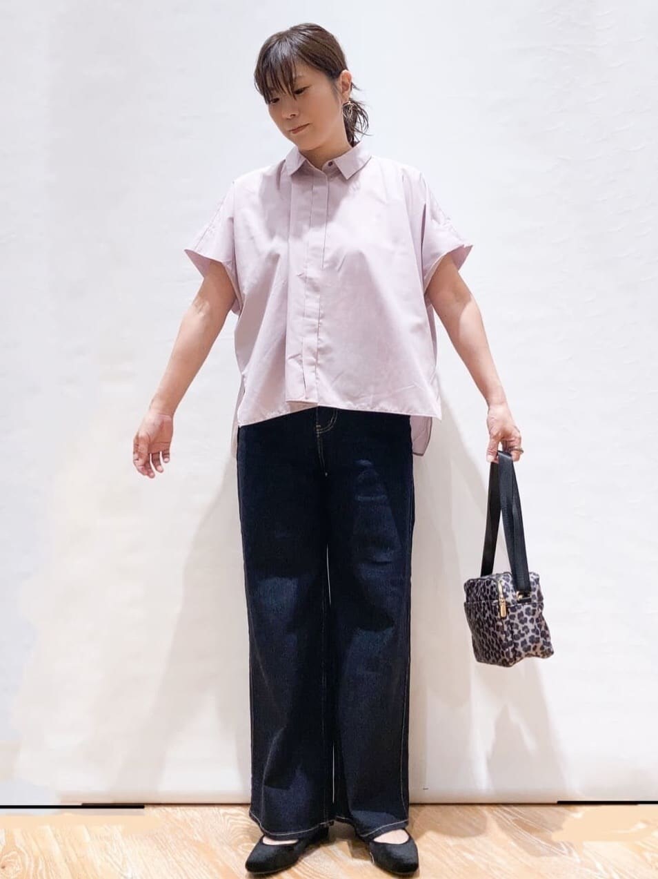 パープル系のシャツ/ブラウス、ブルー系のデニムパンツ、ベージュ系のショルダーバッグを着用したレディースの夏コーディネートの2枚目の写真