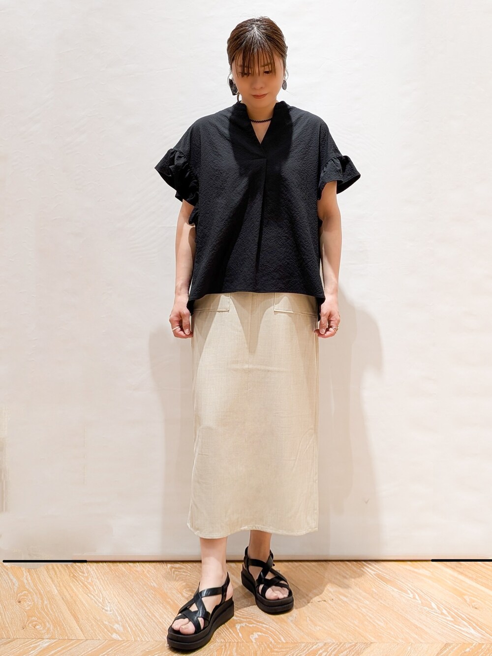 ブラック系のシャツ/ブラウス、ベージュ系のスカート、ホワイト系のトートバッグを着用したレディースの春コーディネートの6枚目の写真