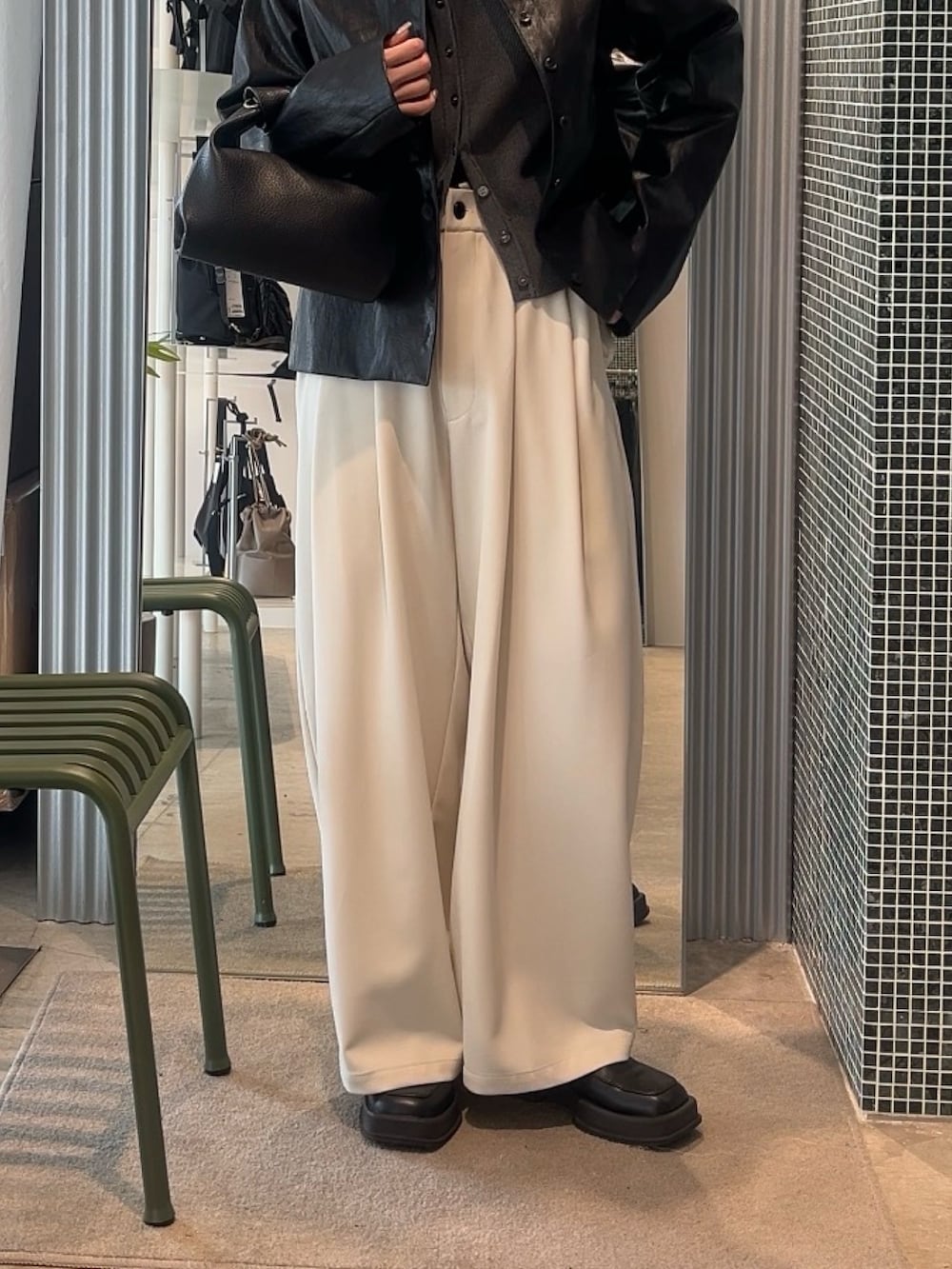 グレー系のスラックス、ブラック系のトートバッグ、グレー系のカーディガン/ボレロを着用したレディースの春コーディネートの4枚目の写真