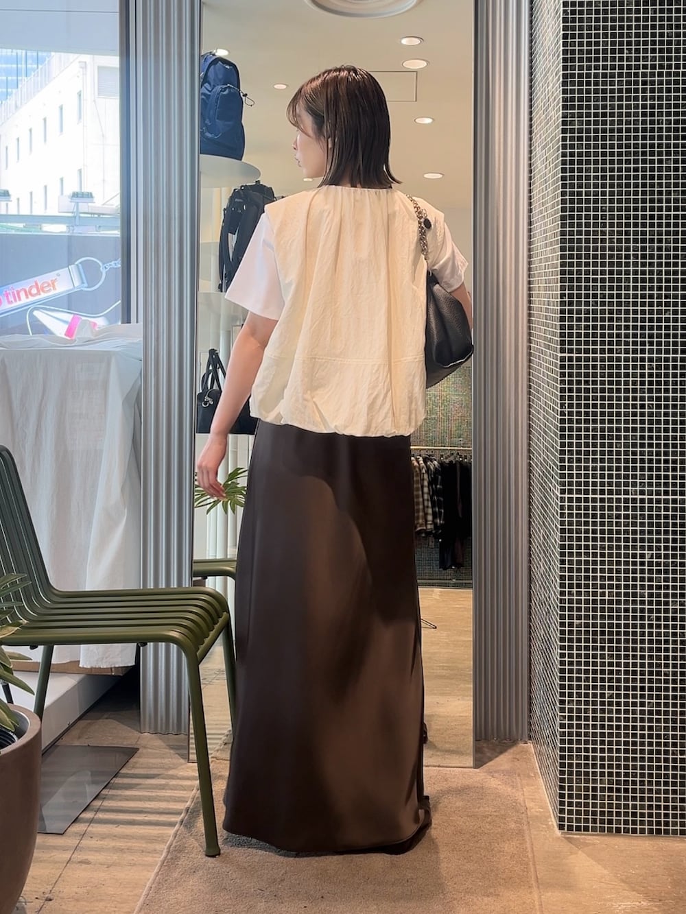 ホワイト系のベスト、ホワイト系のTシャツ/カットソー、ブラック系のトートバッグを着用したレディースの春コーディネートの2枚目の写真