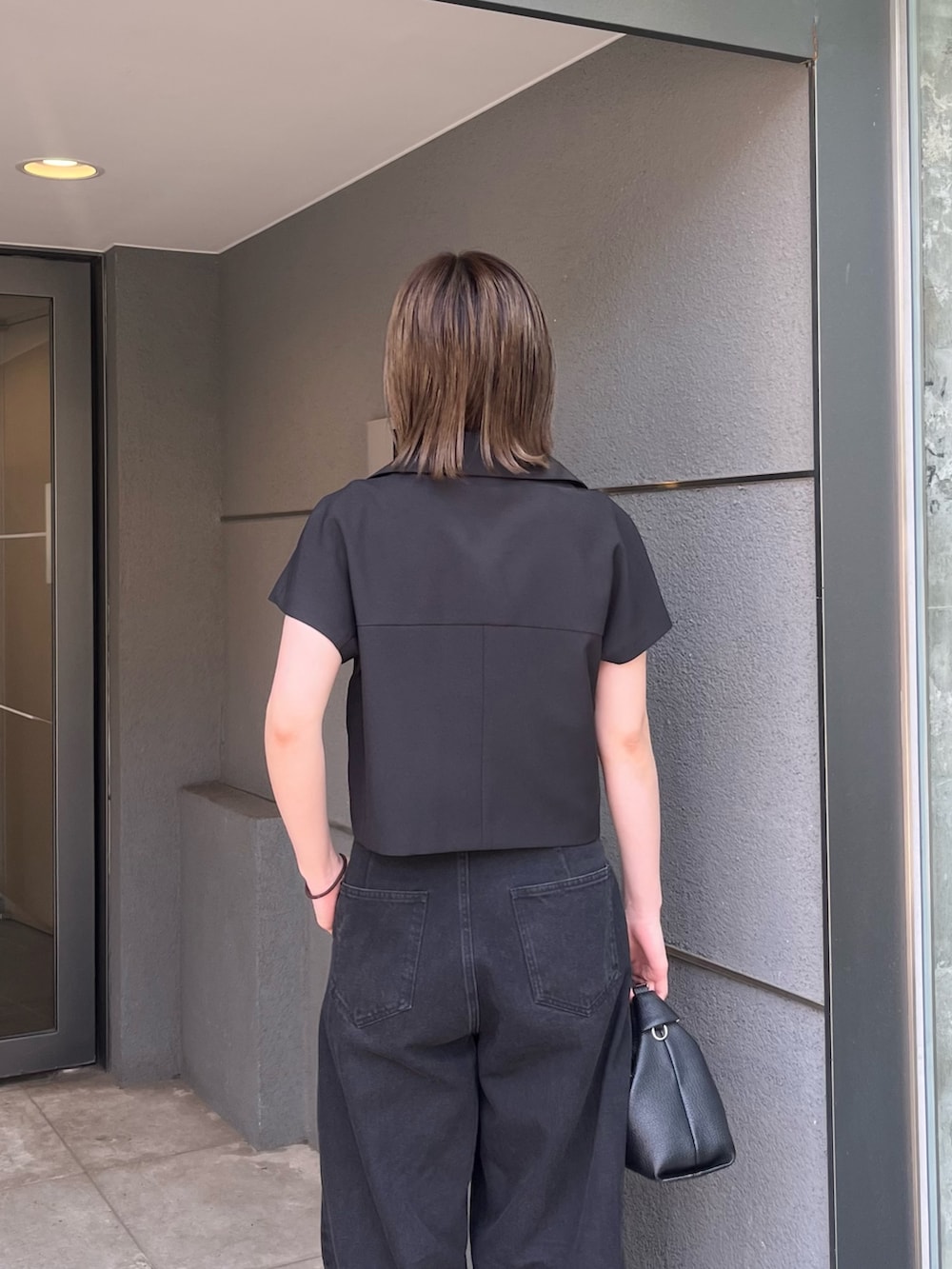 ブラック系のシャツ/ブラウス、ブラック系のデニムパンツ、ブラック系のトートバッグを着用したレディースの夏コーディネートの4枚目の写真