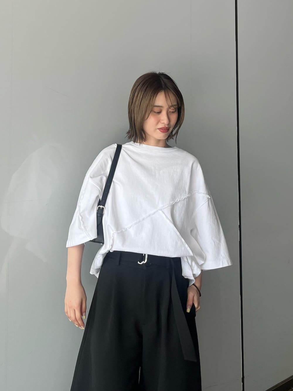 ホワイト系のTシャツ/カットソー、ブラック系のスラックスを着用したレディースの夏コーディネートの3枚目の写真