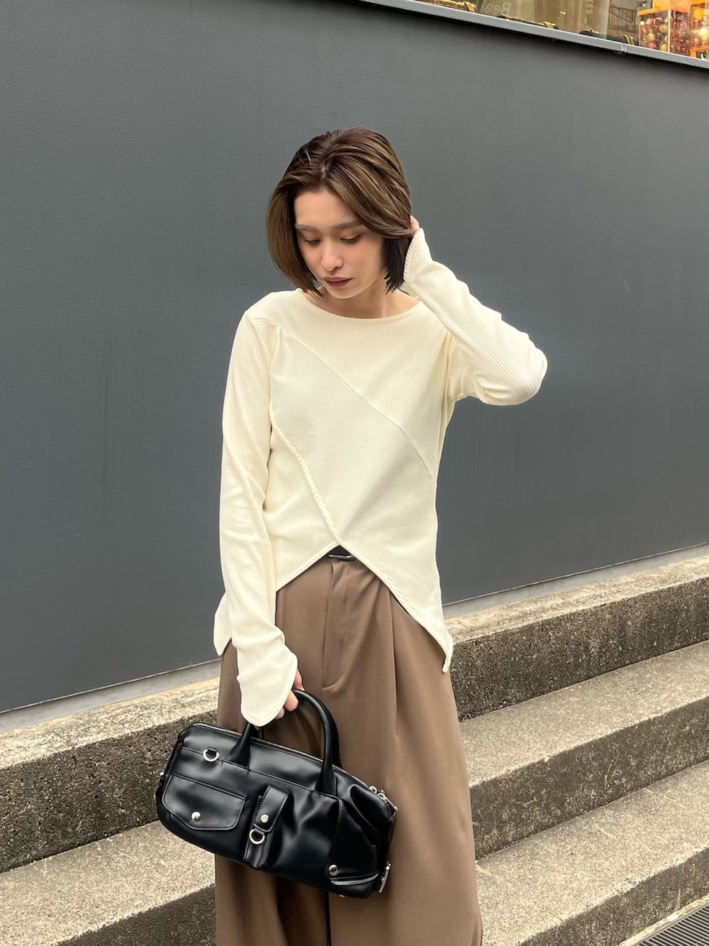 ブラウン系のスラックス、ホワイト系のTシャツ/カットソー、ブラック系のショルダーバッグを着用したレディースの春コーディネートの3枚目の写真