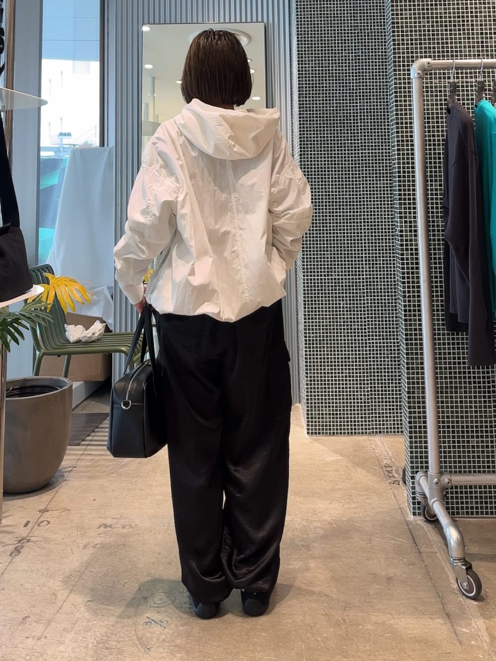 ホワイト系のMA-1、ブラック系のカーゴパンツ、ブラック系のショルダーバッグを着用したレディースの春コーディネートの2枚目の写真