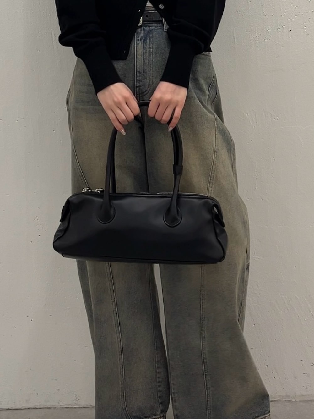 ブルー系のデニムパンツ、ブラック系のカーディガン/ボレロ、ブラック系のトートバッグを着用したレディースの春コーディネートの5枚目の写真