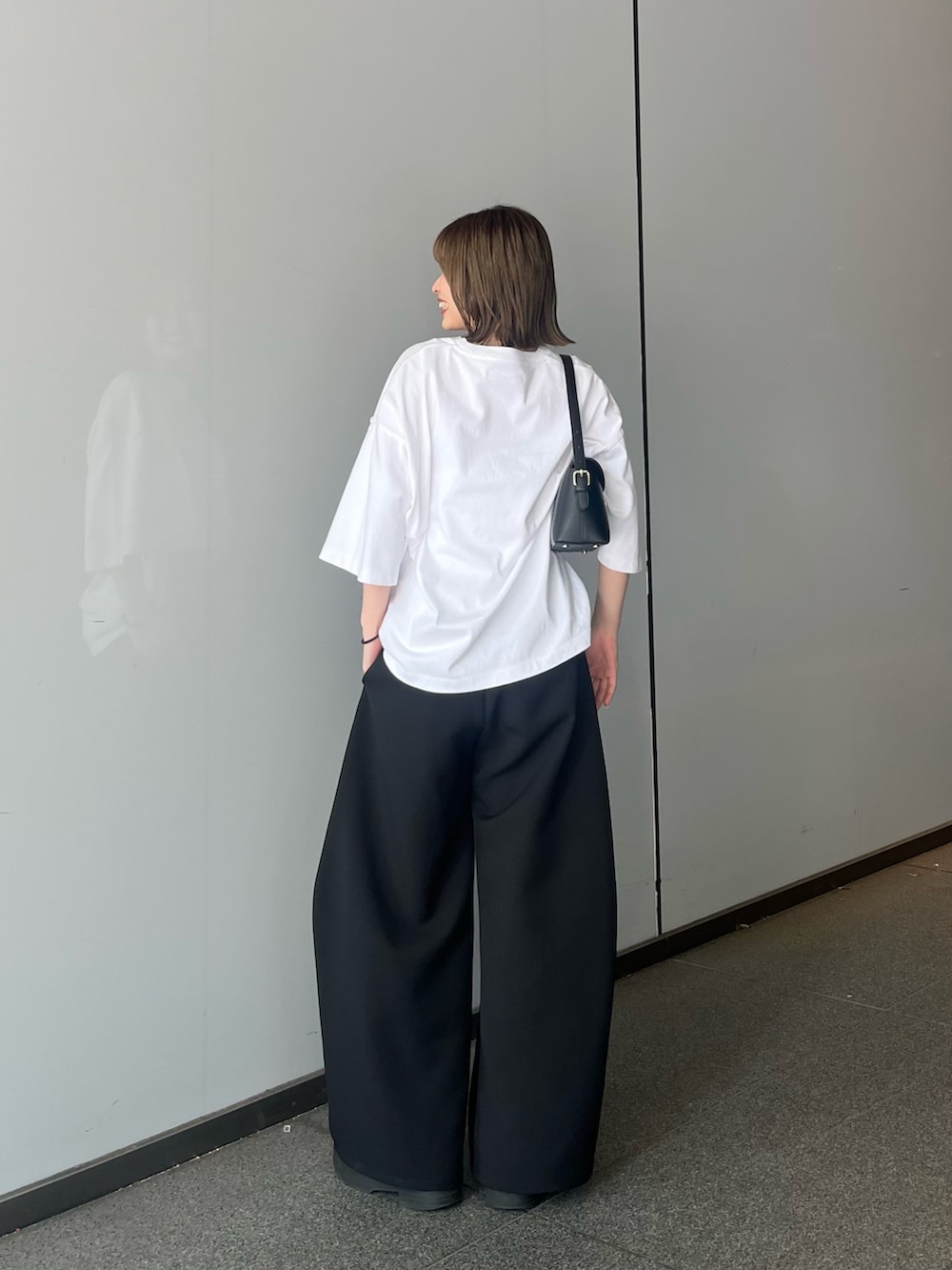 ホワイト系のTシャツ/カットソー、ブラック系のスラックスを着用したレディースの夏コーディネートの2枚目の写真