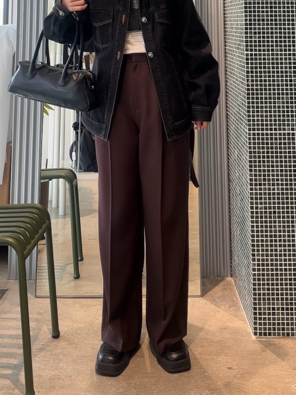 ブラウン系のスラックス、ブラック系のデニムジャケット、ホワイト系のTシャツ/カットソーを着用したレディースの春コーディネートの4枚目の写真