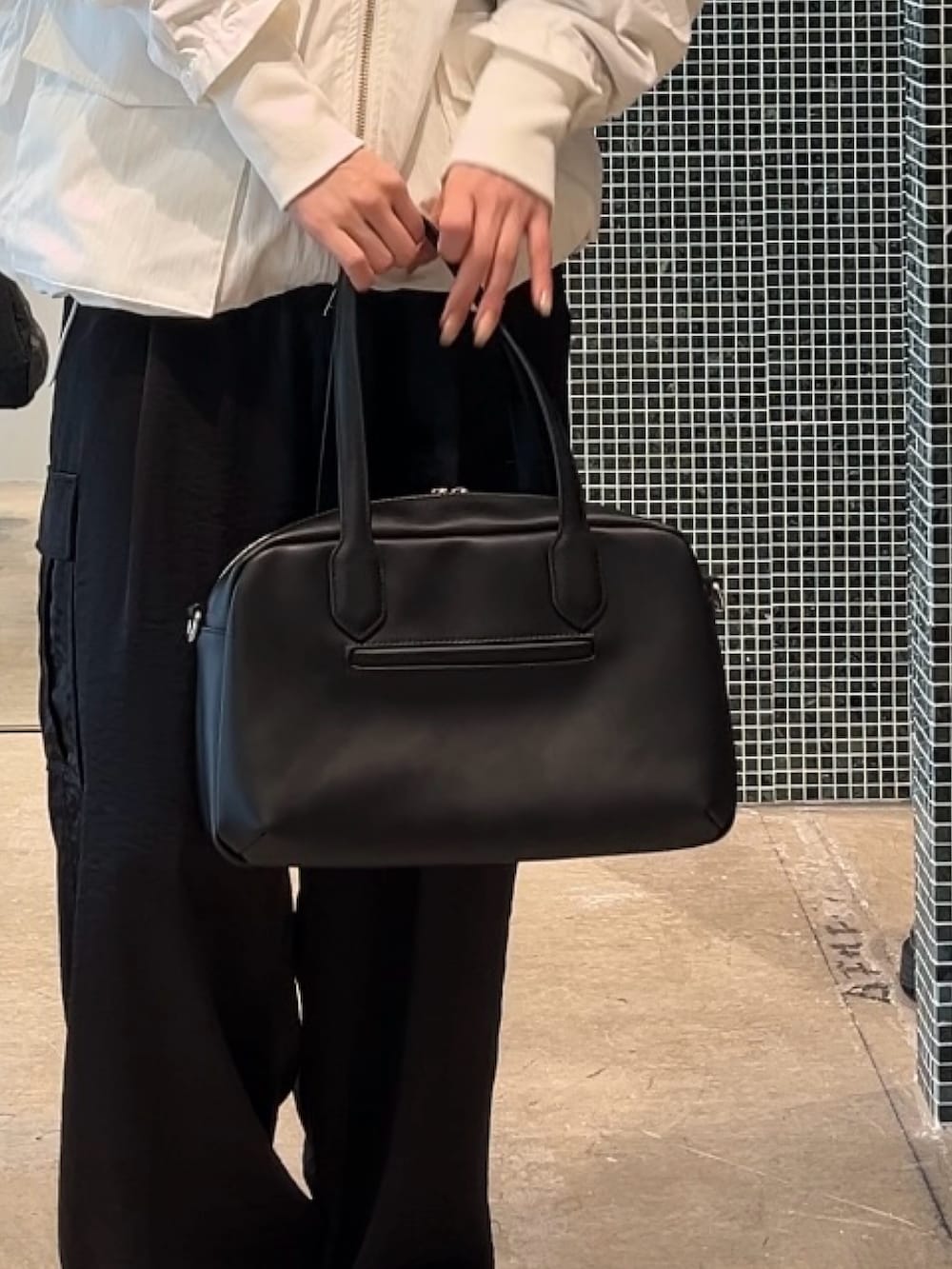 ホワイト系のMA-1、ブラック系のカーゴパンツ、ブラック系のショルダーバッグを着用したレディースの春コーディネートの5枚目の写真