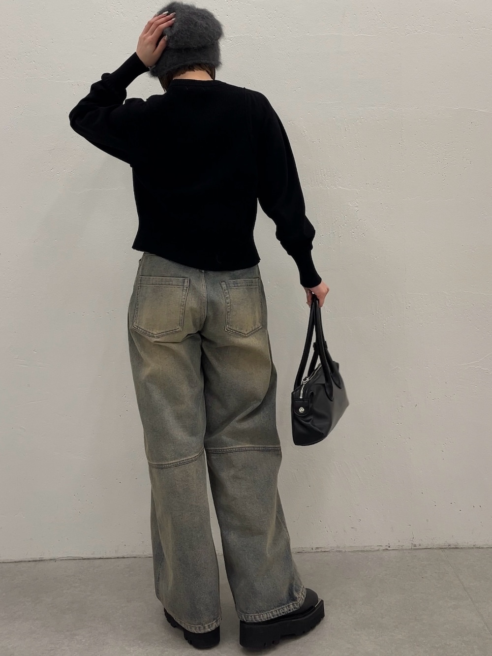 ブルー系のデニムパンツ、ブラック系のカーディガン/ボレロ、ブラック系のトートバッグを着用したレディースの春コーディネートの2枚目の写真