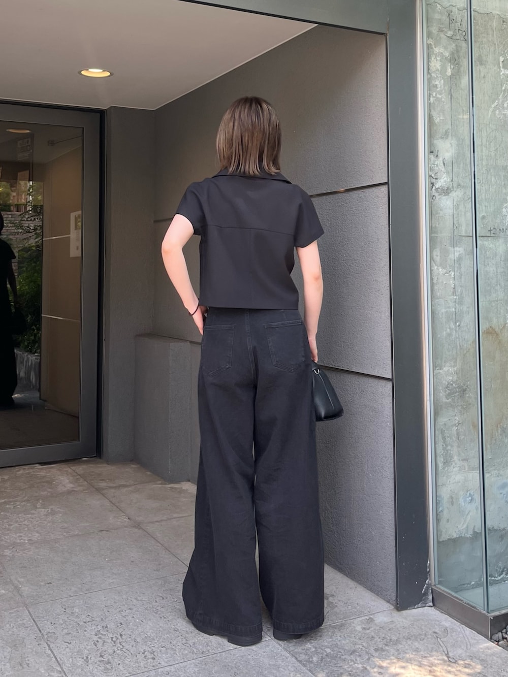 ブラック系のシャツ/ブラウス、ブラック系のデニムパンツ、ブラック系のトートバッグを着用したレディースの夏コーディネートの2枚目の写真