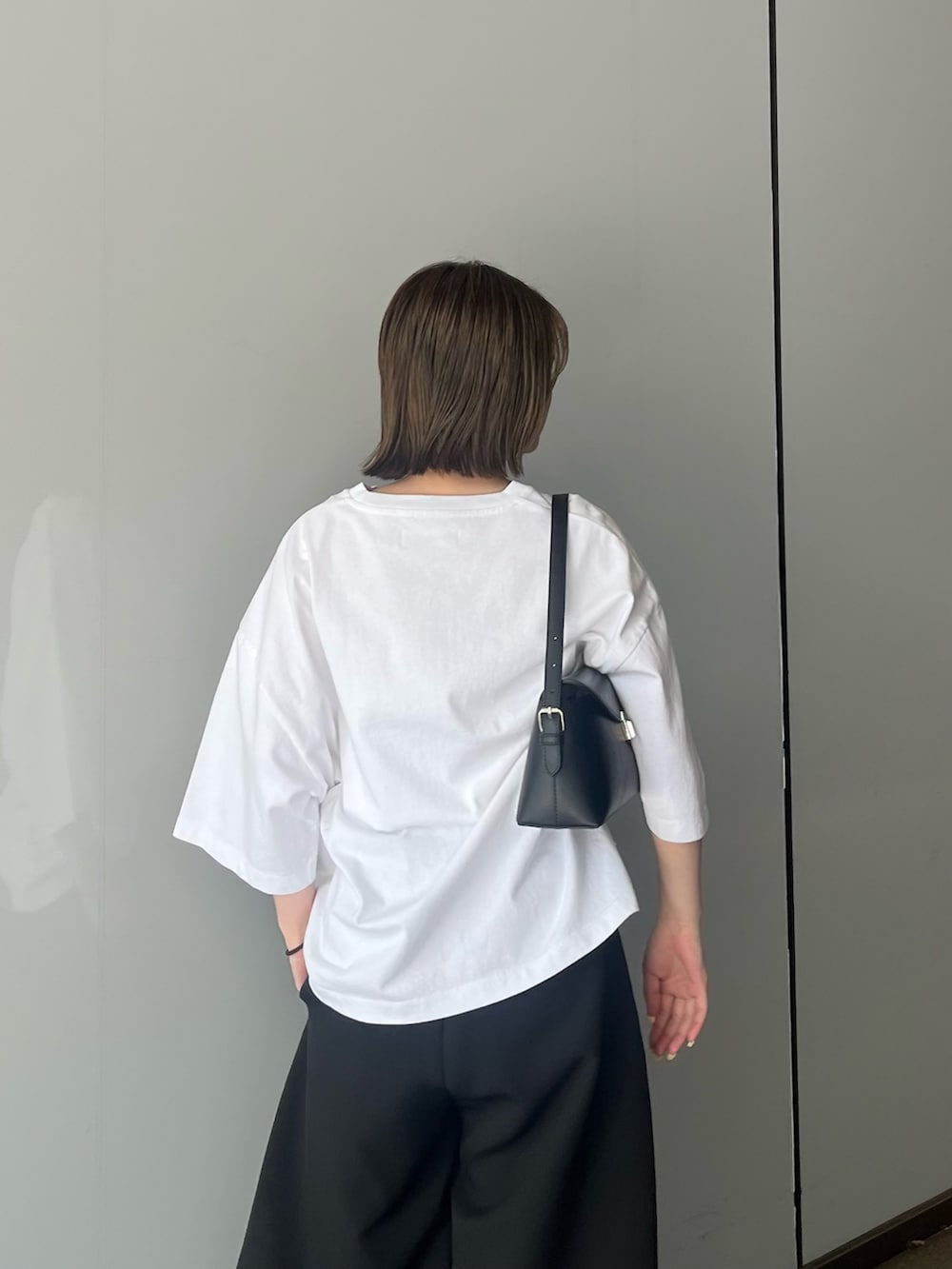 ホワイト系のTシャツ/カットソー、ブラック系のスラックスを着用したレディースの夏コーディネートの4枚目の写真