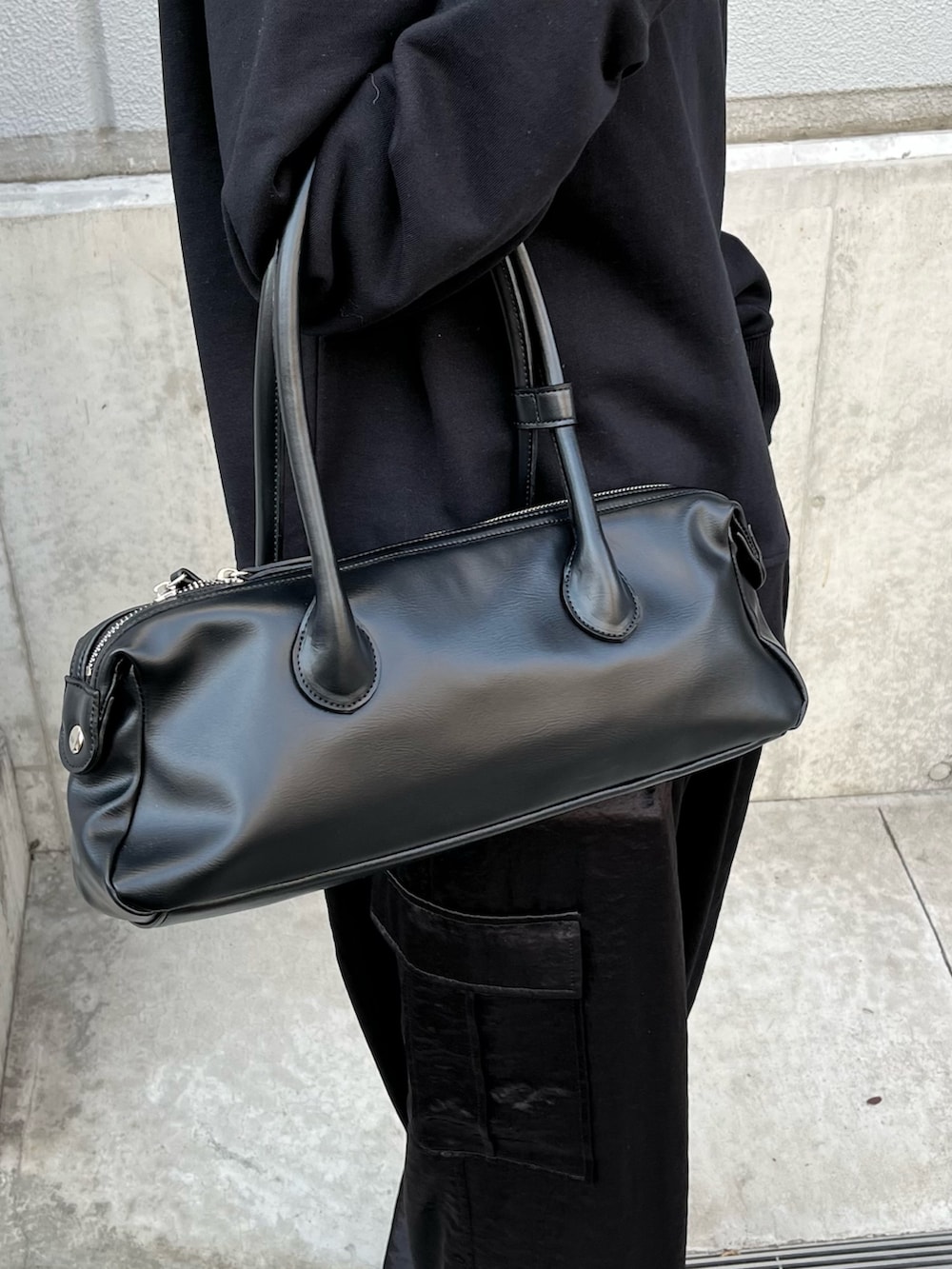 ブラック系のカーゴパンツ、ブラック系のトートバッグ、ブラック系のTシャツ/カットソーを着用したレディースの春コーディネートの5枚目の写真