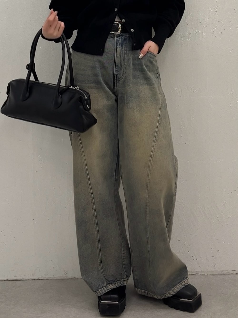 ブルー系のデニムパンツ、ブラック系のカーディガン/ボレロ、ブラック系のトートバッグを着用したレディースの春コーディネートの4枚目の写真