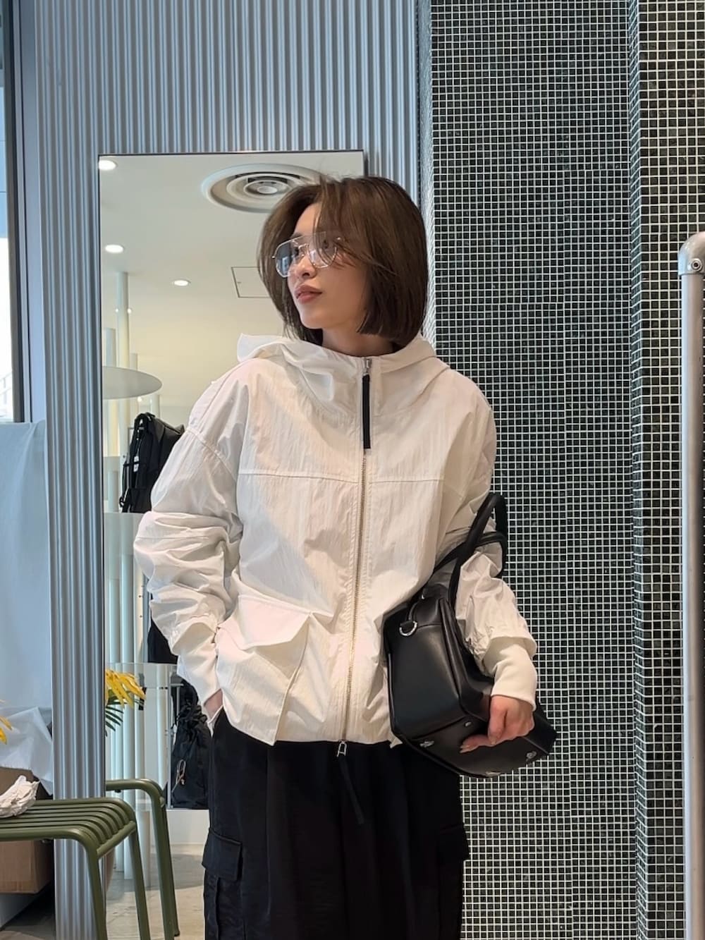 ホワイト系のMA-1、ブラック系のカーゴパンツ、ブラック系のショルダーバッグを着用したレディースの春コーディネートの3枚目の写真